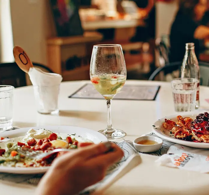 A table with plates of food and wine on it.