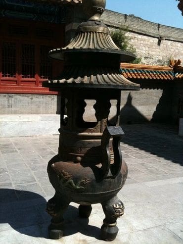 A statue of an elephant with a pagoda like roof.