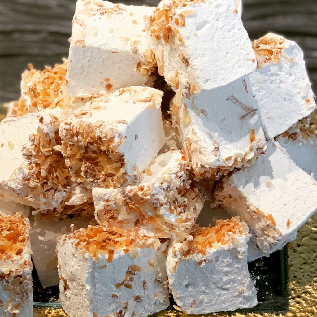 A pile of marshmallows covered in toasted coconut.