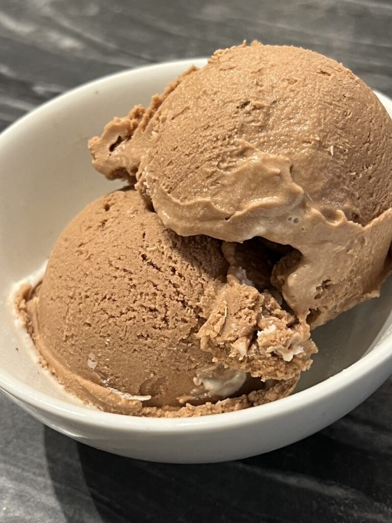 Two scoops of ice cream in a bowl.