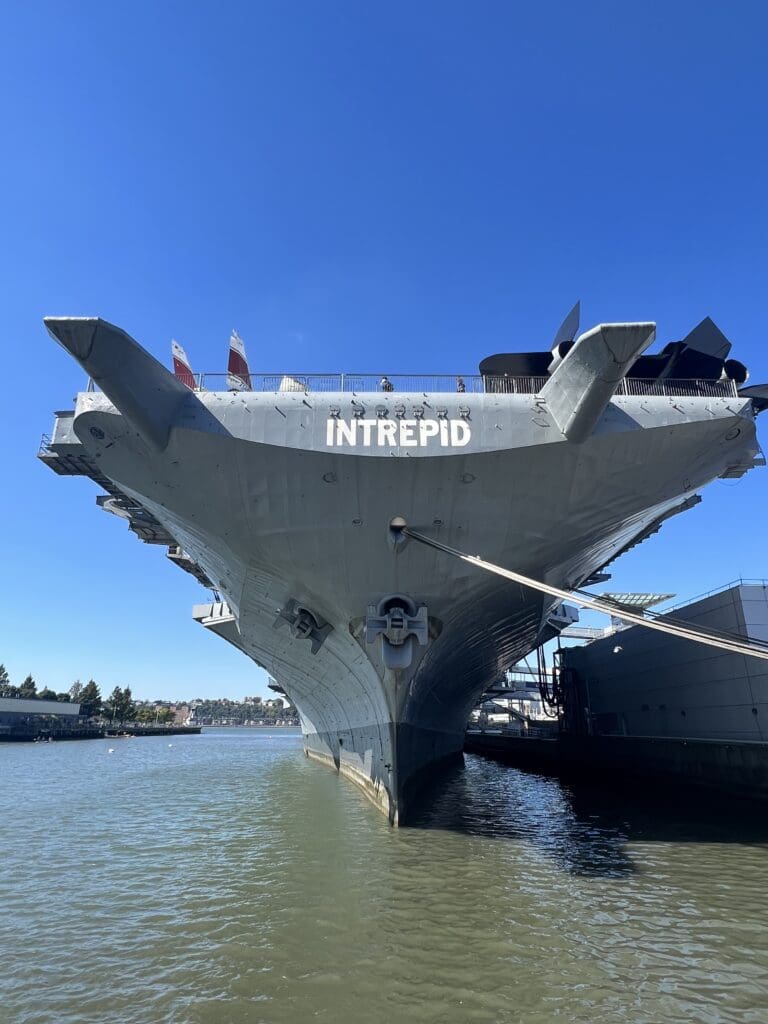 A large aircraft carrier is docked in the water.