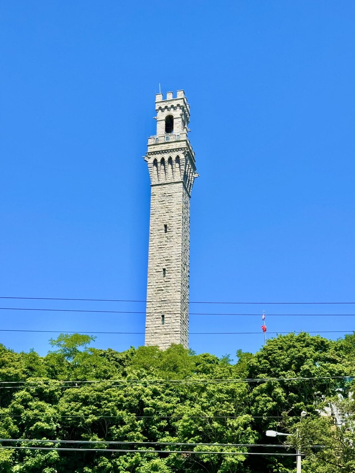 A tall tower with a clock on it's side.